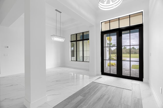 entrance foyer featuring ornamental molding and a notable chandelier