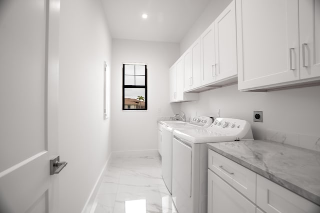 washroom with cabinets, sink, and separate washer and dryer