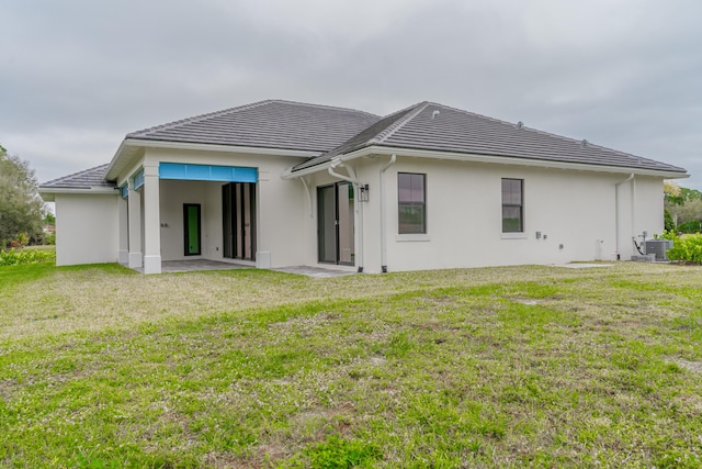 back of house with central AC and a lawn