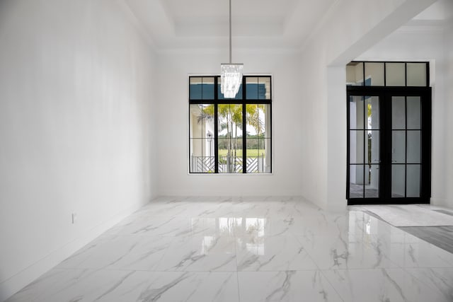 unfurnished room with french doors, a notable chandelier, ornamental molding, and a tray ceiling