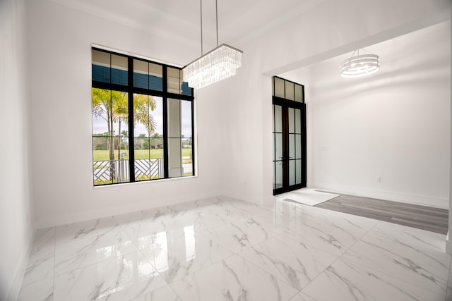 empty room with a chandelier and crown molding