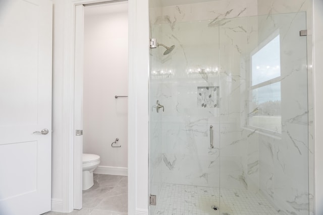 bathroom with a shower with door and toilet