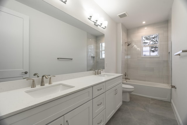 full bathroom featuring vanity, tiled shower / bath combo, toilet, and tile patterned flooring