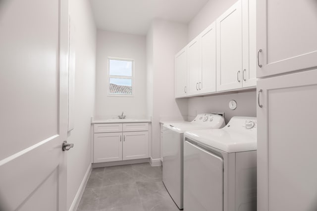 laundry room featuring cabinets, sink, and washer and clothes dryer