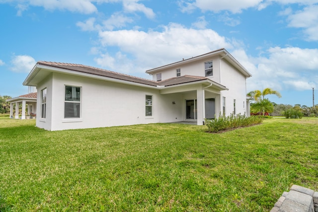 rear view of house featuring a yard and a patio