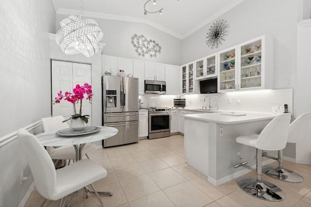 kitchen featuring white cabinets, pendant lighting, stainless steel appliances, and kitchen peninsula