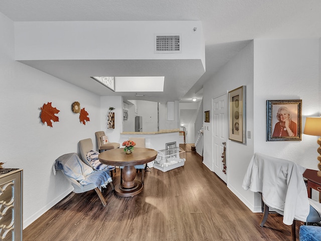 dining space featuring hardwood / wood-style floors and a skylight