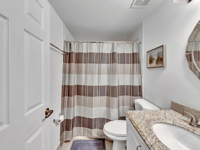 bathroom featuring vanity, toilet, and walk in shower