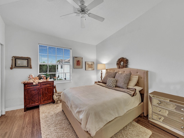 bedroom with lofted ceiling, hardwood / wood-style floors, and ceiling fan