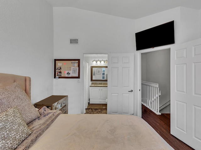 bedroom featuring ensuite bathroom, lofted ceiling, and dark hardwood / wood-style floors