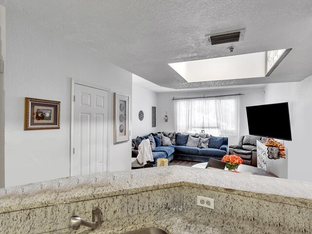 living room featuring a textured ceiling and sink