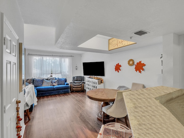 living room with dark hardwood / wood-style floors and a textured ceiling