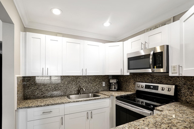 kitchen with sink, crown molding, white cabinets, appliances with stainless steel finishes, and light stone counters