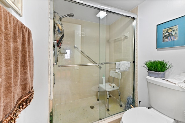 bathroom featuring toilet and an enclosed shower