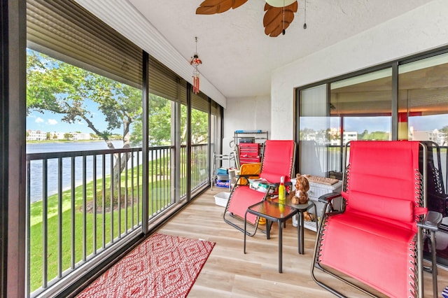 sunroom with a water view, ceiling fan, and plenty of natural light