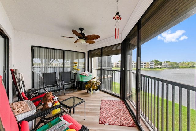 sunroom featuring a water view and ceiling fan