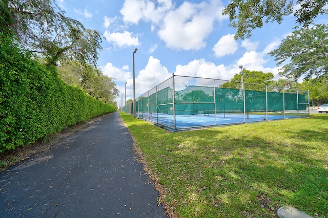 view of sport court with a lawn