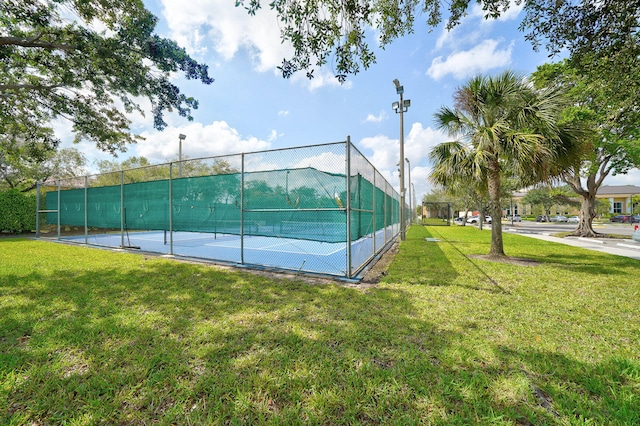 view of tennis court with a yard