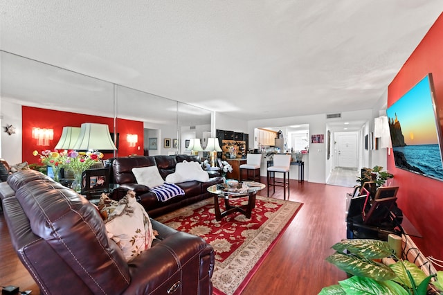 living room featuring a textured ceiling and wood-type flooring