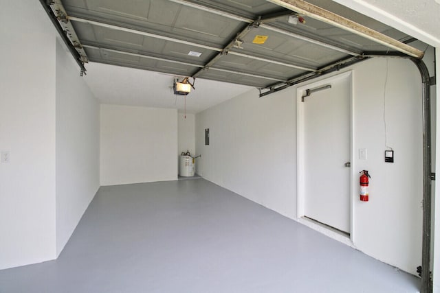 garage with a garage door opener and electric water heater