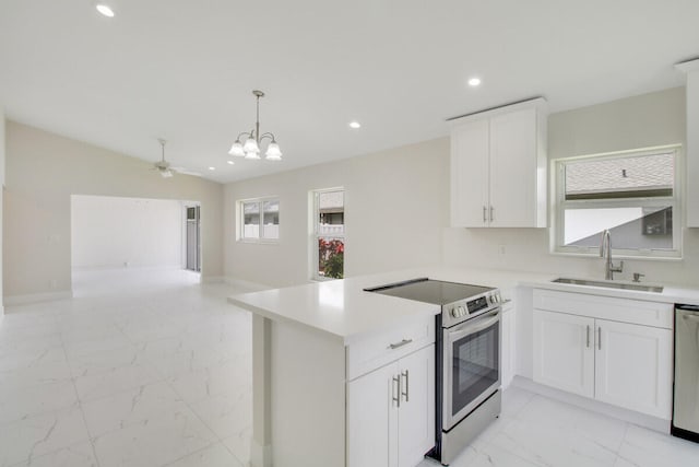 kitchen featuring sink, kitchen peninsula, stainless steel appliances, pendant lighting, and white cabinets