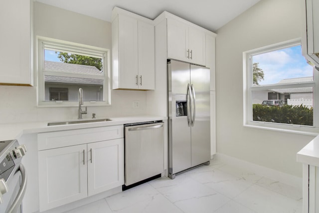 kitchen featuring white cabinetry, stainless steel appliances, sink, and a wealth of natural light