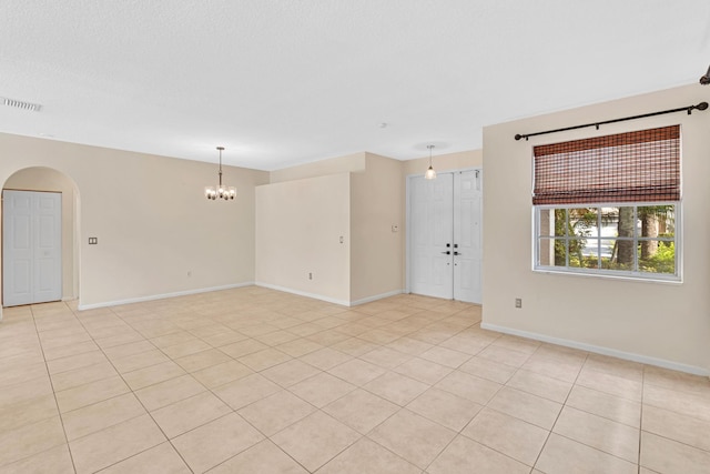 tiled empty room with a chandelier