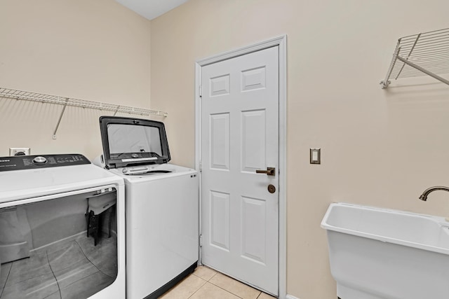 clothes washing area featuring washing machine and clothes dryer and light tile patterned floors