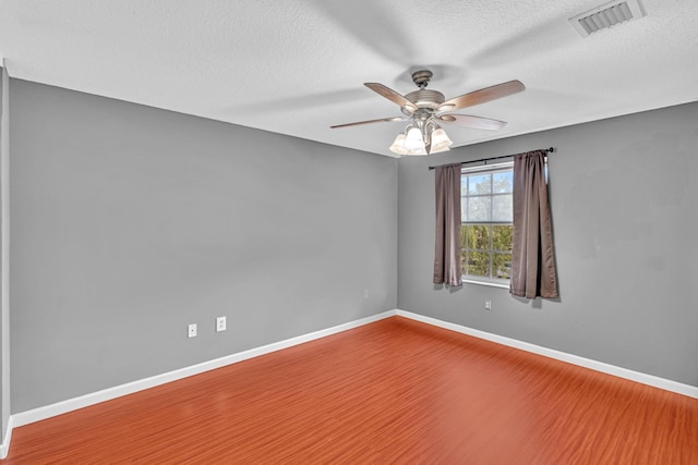 spare room with ceiling fan, a textured ceiling, and hardwood / wood-style floors