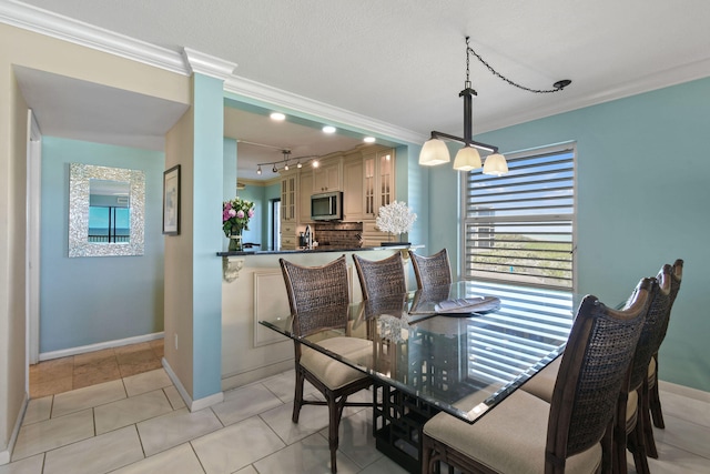 tiled dining area featuring crown molding, a textured ceiling, a chandelier, and rail lighting