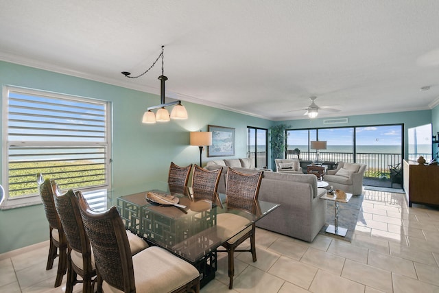 tiled dining room featuring crown molding, a textured ceiling, a water view, and ceiling fan