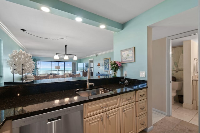 kitchen featuring light tile patterned floors, dark stone counters, ornamental molding, dishwasher, and sink