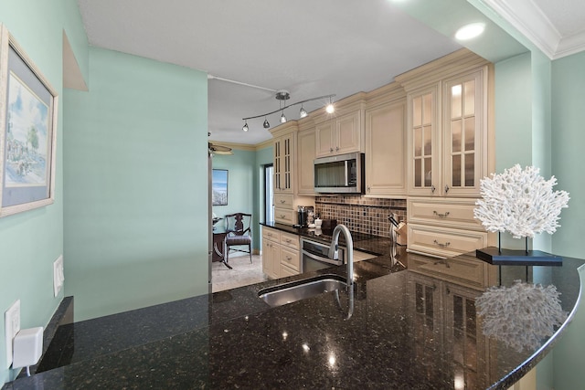 2571 NE Ocean Blvd Unit 10-203, Stuart, FL 34996 - kitchen with cream cabinetry, stainless steel microwave, a sink, tasteful backsplash, and dark stone countertops