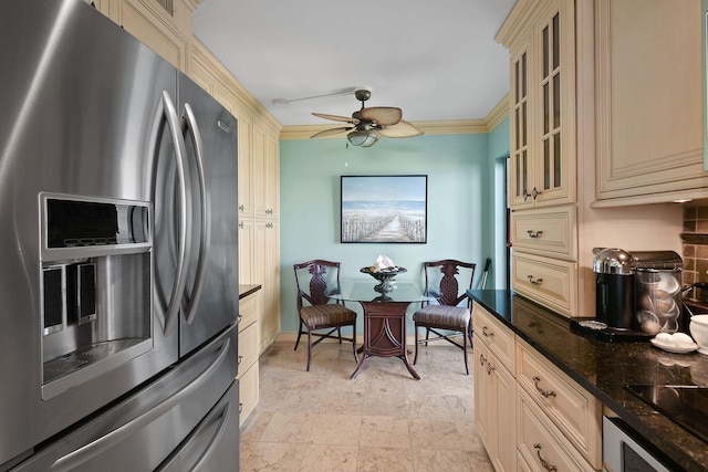 kitchen featuring appliances with stainless steel finishes, crown molding, dark stone counters, and cream cabinetry