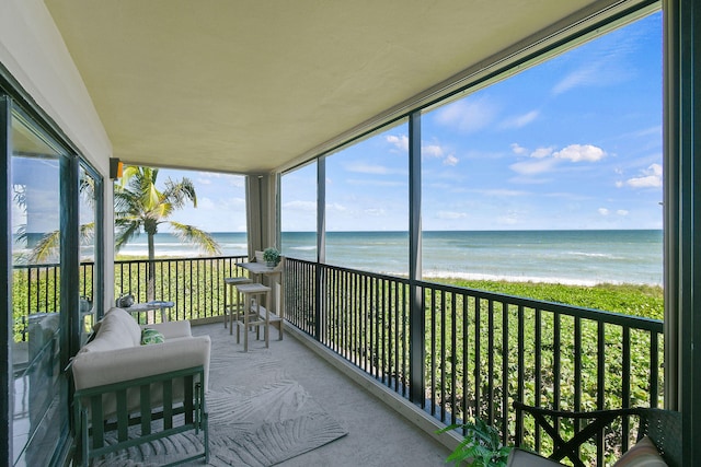 sunroom featuring a wealth of natural light and a water view