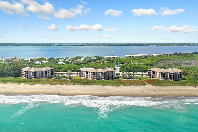 birds eye view of property featuring a water view and a beach view