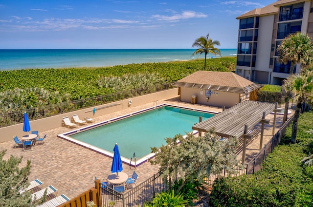 view of swimming pool with a patio area and a water view