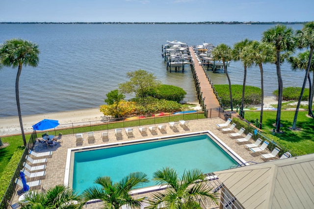 view of pool featuring a patio area, a water view, and a boat dock