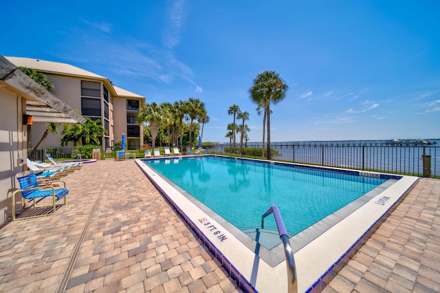 view of swimming pool with a patio and a water view