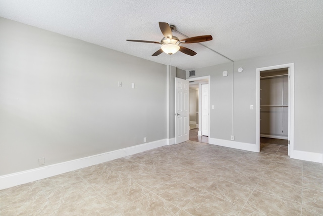 unfurnished bedroom with visible vents, ceiling fan, a textured ceiling, and baseboards