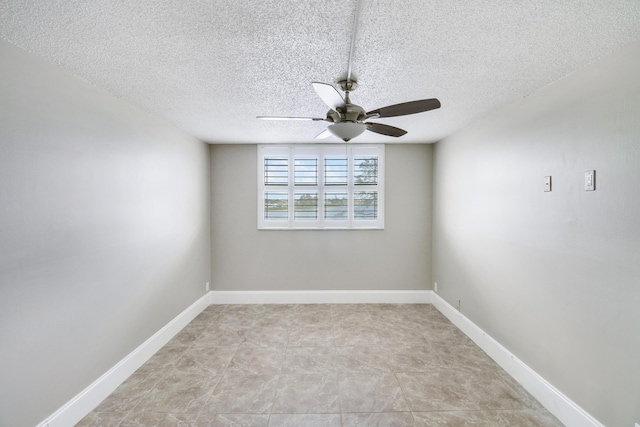 empty room with ceiling fan, baseboards, and a textured ceiling