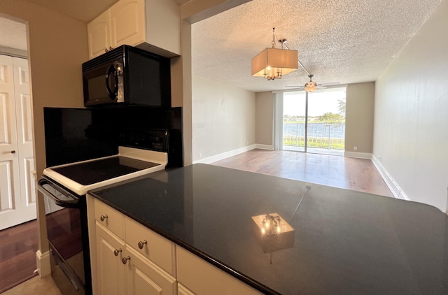 kitchen with dark countertops, electric range oven, a textured ceiling, light wood-type flooring, and black microwave