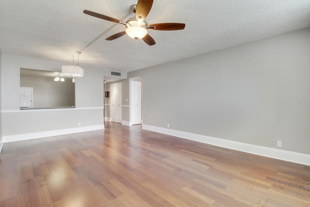 unfurnished room featuring baseboards, visible vents, and wood finished floors