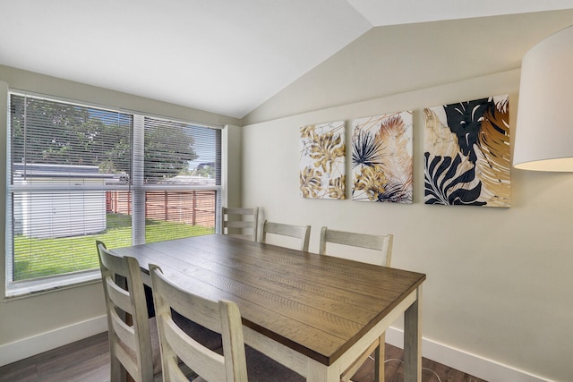 dining space featuring lofted ceiling and dark hardwood / wood-style floors