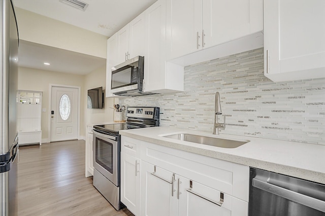 kitchen featuring light hardwood / wood-style flooring, white cabinetry, sink, and stainless steel appliances