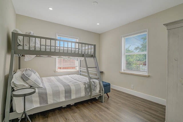 bedroom with wood-type flooring and multiple windows