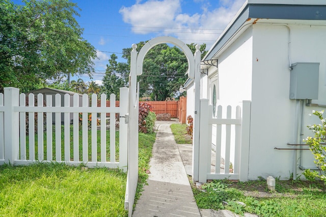 view of gate with a lawn