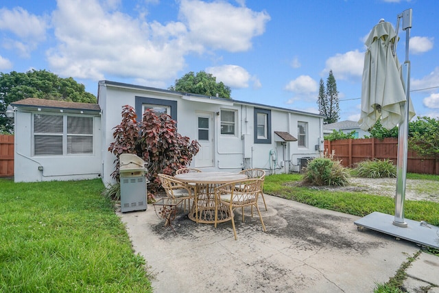 back of property featuring a patio and a lawn