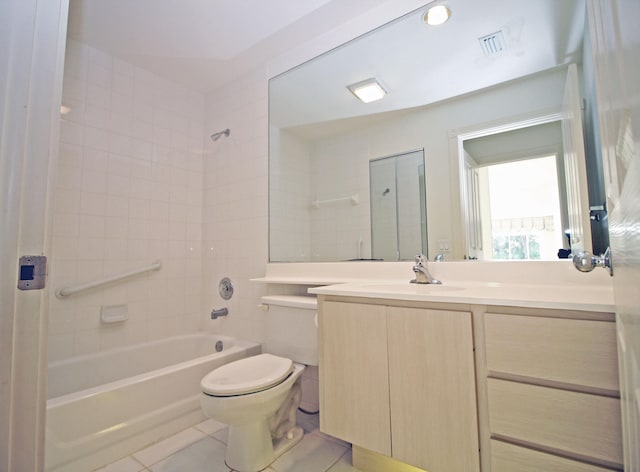 full bathroom featuring tiled shower / bath, vanity, toilet, and tile patterned floors