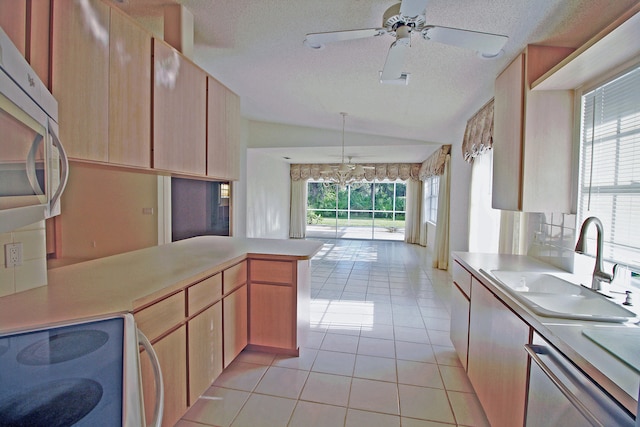 kitchen featuring a textured ceiling, hanging light fixtures, stainless steel appliances, vaulted ceiling, and light tile patterned floors